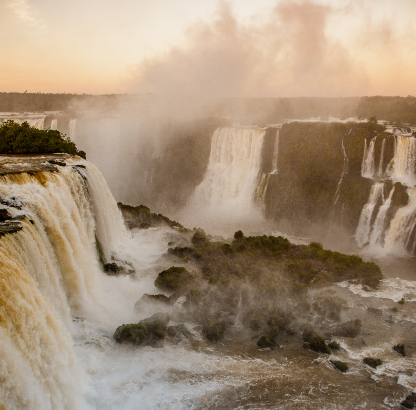 Visitors overlooking Iguaçu Falls at sunrise
